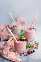 Glasses of berry smoothie on light background.