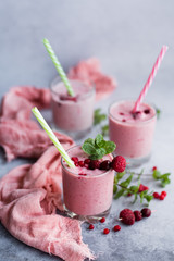 Glasses of berry smoothie on light background.