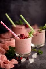 Glasses of berry smoothie on dark background.