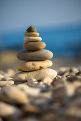 Fototapeta na wymiar Cairn on the pebbles on sea background
