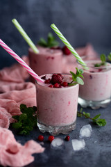 Glasses of berry smoothie on dark background.