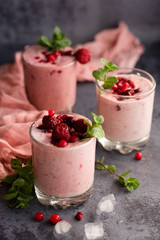 Glasses of berry smoothie on dark background.