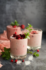 Glasses of berry smoothie on dark background.