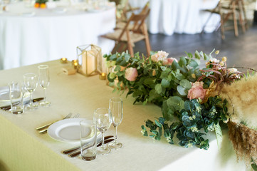 Classic serving in the restaurant, plates of glasses, and forks.Making a pampas grass and greenery. Floristics.