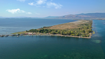 Fototapeta premium Aerial drone photo of artificial sea salt ponds in area Tourlida of Kleisova lagoon featuring seaside traditional settlement, Mesolongi, Aitoloakarnania, Greece