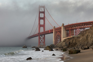 The Golden Gate Bridge in downtown San Fransisco covered in fog, as seen from Marshall's Beach