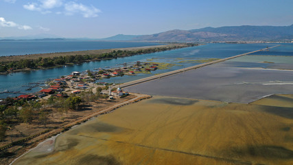 Aerial drone photo of artificial sea salt ponds in area Tourlida of Kleisova lagoon featuring seaside traditional settlement, Mesolongi, Aitoloakarnania, Greece