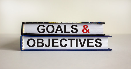 Books with text 'goals and objectives' on beautiful white background. Business concept. Copy space.