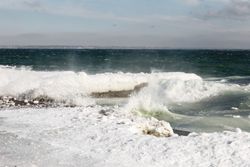 Winter seascape. Snow, ice huge waves beating against the shore and freezes. Natural disaster in form of storms and severe frosts led to icing of the black sea coast near Odessa.