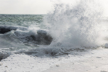 Naklejka premium Winter seascape. Snow, ice huge waves beating against the shore and freezes. Natural disaster in form of storms and severe frosts led to icing of the black sea coast near Odessa.