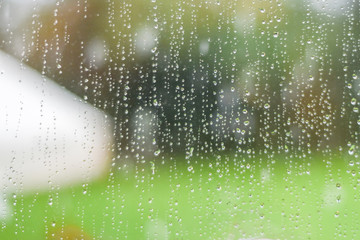 Heavy rain splashes from a garden umbrella during rainfall