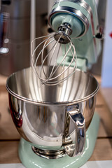 Stainless steel light green electric mixer. Hand or stand mixer. Kitchen device. Selective focus macro close-up