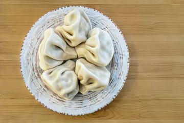 homemade georgian dumplings Khinkali with meat on a porcelian plate on a wooden table
