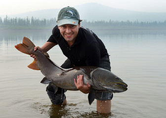 Happy man - success angler holds a big fish