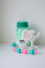 Large silicone clip for baby pacifier and milk bottle on white background. Soft toy in the form of an elephant. Beautiful accessories for a newborn. The concept of happy motherhood and childhood.