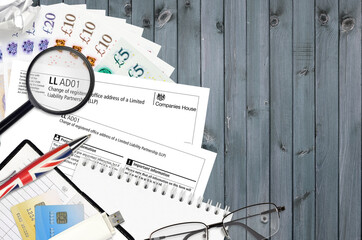 English form LLAD01 Change of registered office address of a limited liability partnership LLP from Companies House service lies on table with office items