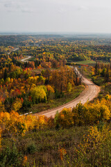 A top view of colourful forest trees and road in the autumn season. Perm, Russia