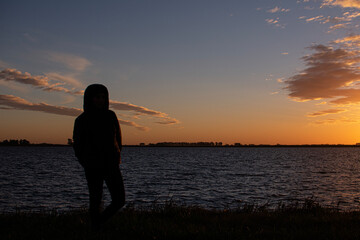 Fototapeta na wymiar Girl See Sunset Over the Lake