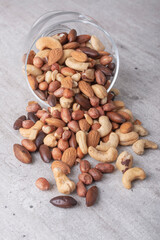 Glass bowl full of mixed nuts over a wooden background. Peanuts, brazilian nuts, cashew nuts, baru nuts and almonds