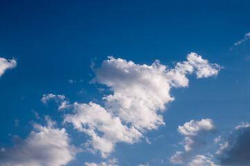 Clouds in the blue sky. Sunny day. Clouds floating across the sky. The clouds are illuminated by the sun's rays.