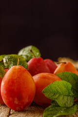 Still life with fresh organic plums on wooden background