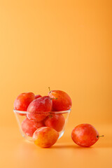 Still life with fresh organic plums on color background