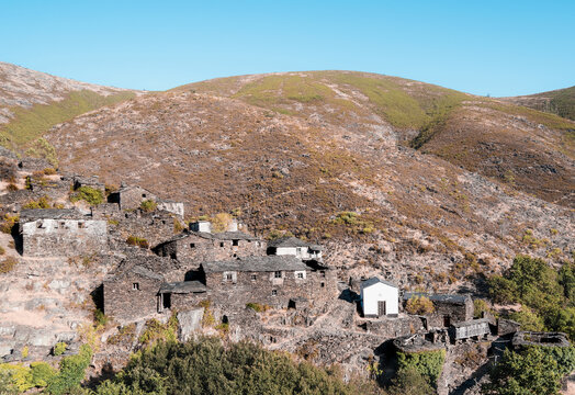 Stone houses on a hill in Drave, an abandoned village in Portugal.