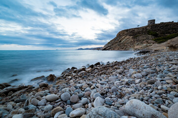 Villajoyosa mediterranean coastline, Alicante,  in sunset with the view of the beach, cliffs and a tower