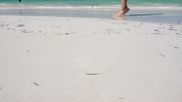 Woman legs, walking along the beach. Leaving footprints on sand. Summer vacation. Travel destinations