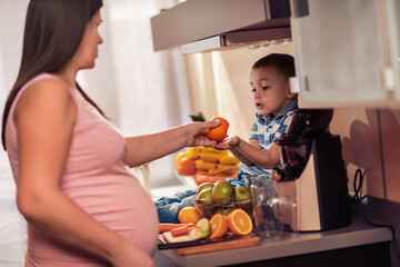 Mother and child making fresh orange juice