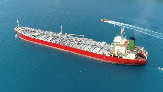 Supertanker loaded with full of oil underway in the open sea. Oil chemical tanker ploughs through the water. Aerial tracking video of a 182 meters long tanker ship
