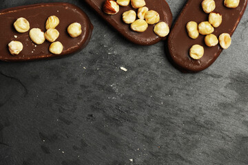 top view of chocolate ice creams on a dark slate background with hazelnuts. flat lay . food menu concept