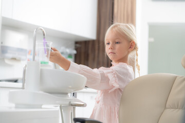 A close-up of a little girl in a dentist office. Children visiting dentists concept. Tooth healthcare concept.