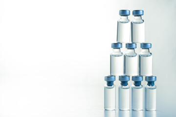 Many transparent vials with vaccine for covid-19 coronavirus, flu, infectious diseases. Injection after clinical trials for vaccination of human, child, adult, senior. Medicine, drug concept