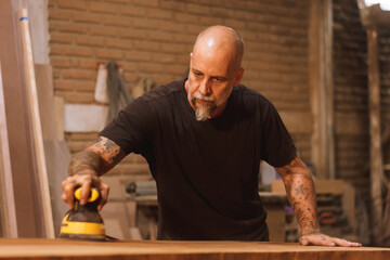 Carpintero mexicano artesano con tabla de madera lijando