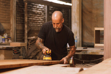 Carpintero mexicano artesano con tabla de madera lijando