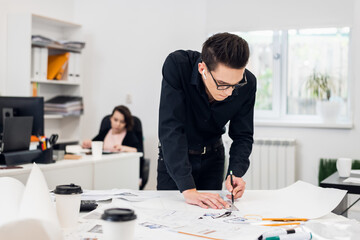 An engineer supervisor working on the drawings in the office.
