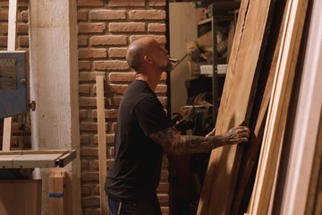 Hombre mexicano maduro carpintero en taller con madera trabajando