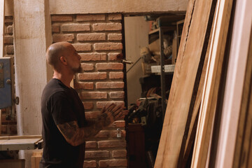 Hombre mexicano maduro carpintero en taller con madera trabajando