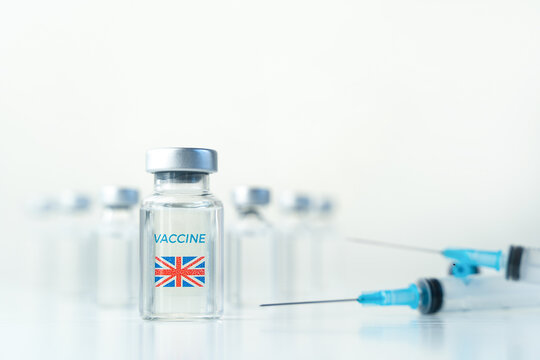 Transparent Vials With UK Flag. Vaccine, Syringes For Covid-19 Coronavirus, Flu, Infectious Diseases.Injection After Clinical Trials For Vaccination Of Human,child,adult,senior.Medicine, Drug Concept