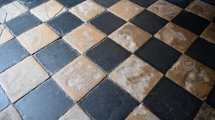 Old chessboard mosaic tile in a old church in brittany