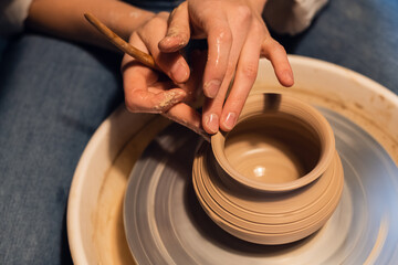 a master in a pottery workshop shows the technique of modeling a pot on a Potter's wheel