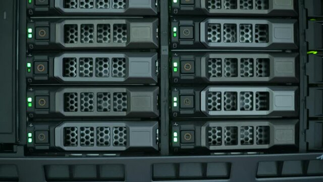 front panel of a server cabinet with hard drives and blinking lights, close up. information recording process