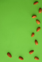 Almonds on a green background, empty space