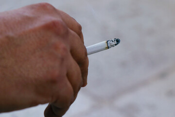 burning cigarette with smoke on a hand