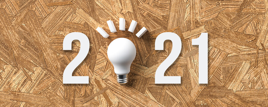 lightbulb and number 2021 on wooden background