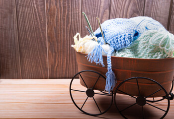 Knitting yarn and needles on Metal basket  over wood Background with copy space.