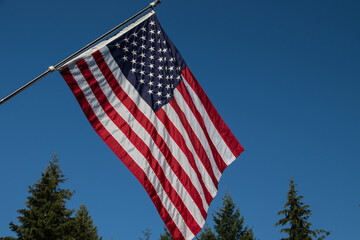Old Glory - the American flag flying in the breeze with a blue sky background