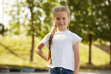 Portrait of a little girl in a white t-shirt in the Park Sunny day