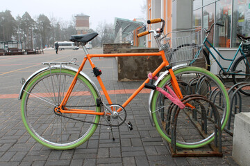 Fototapeta na wymiar Colorfull hipster bike parked near a railway station in a cold cloudy day